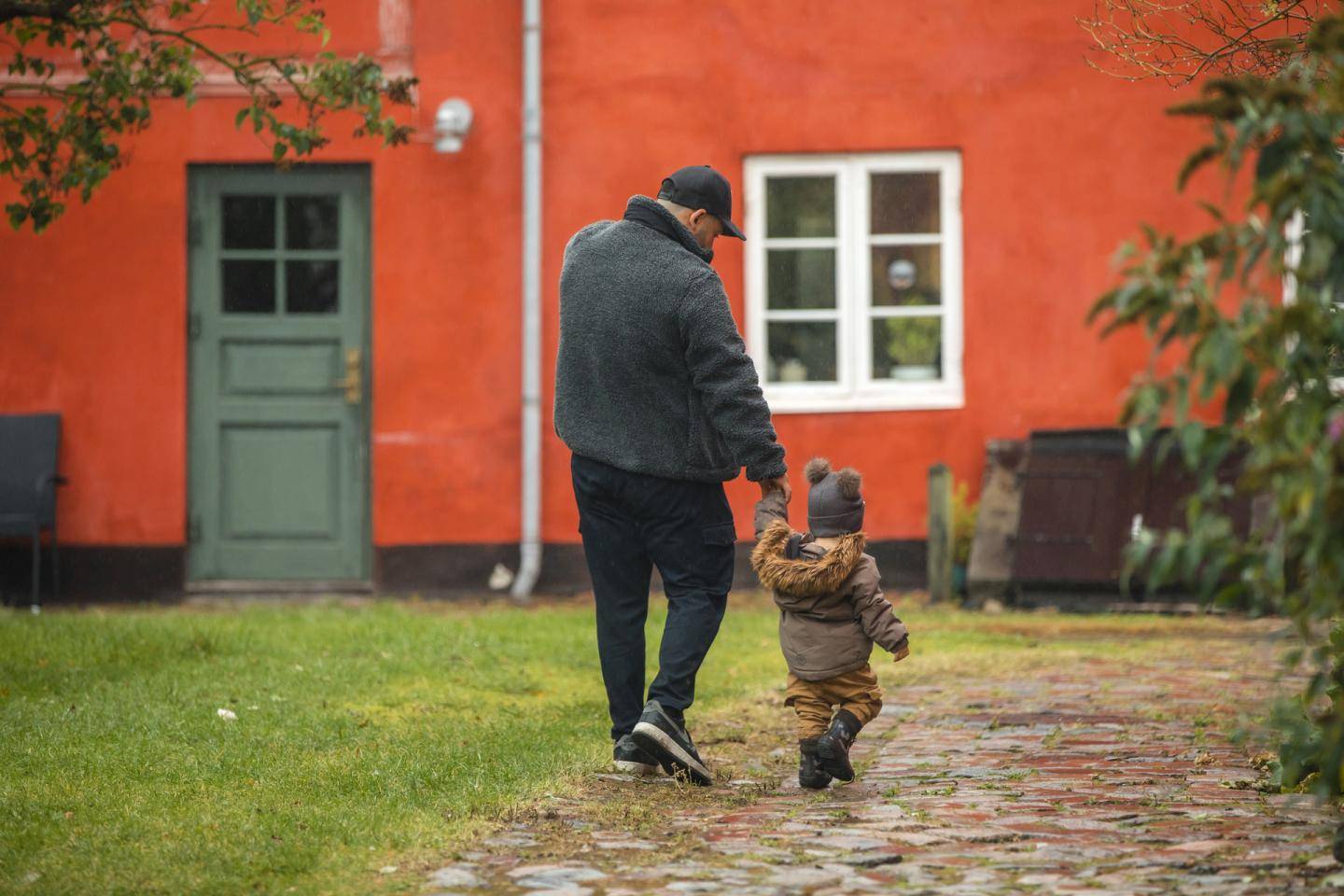 Voksen går med barn i hånden
