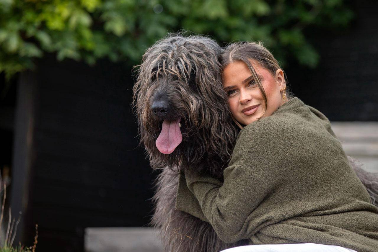 Pige, som krammer en hund
